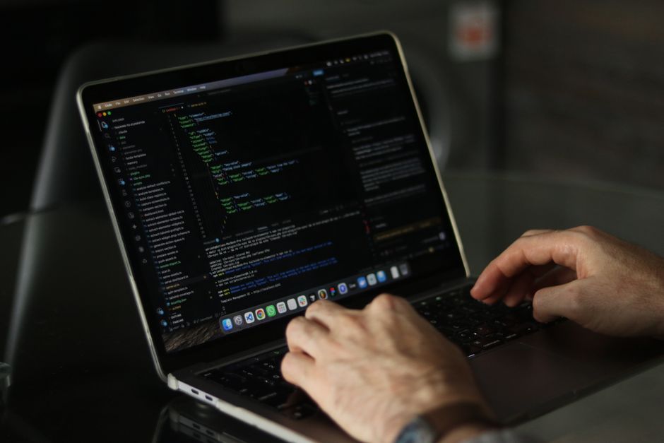 Розробник пише код інтеграції між системами за ноутбуком